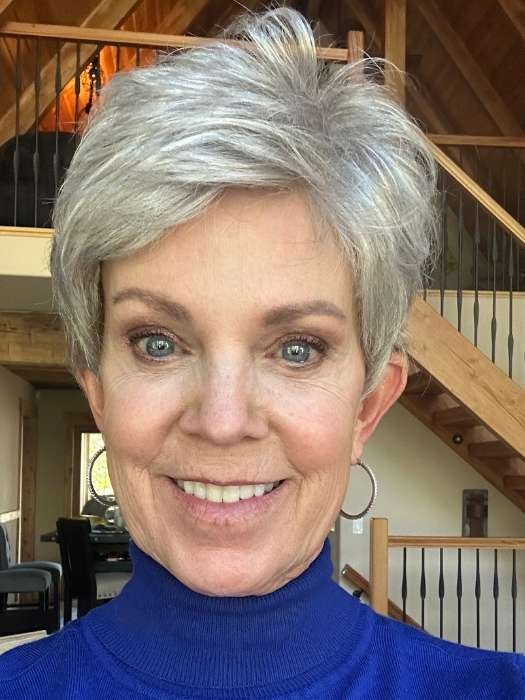 Ellen Wille Tab wig short silver pixie on smiling woman wearing blue turtleneck and hoop earrings
