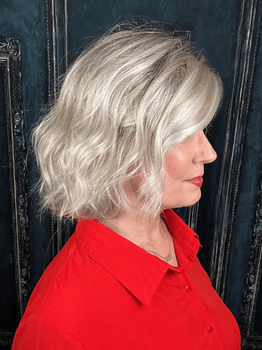 short silver blonde wig for women styled as a wavy chin length bob on a model in a red blouse