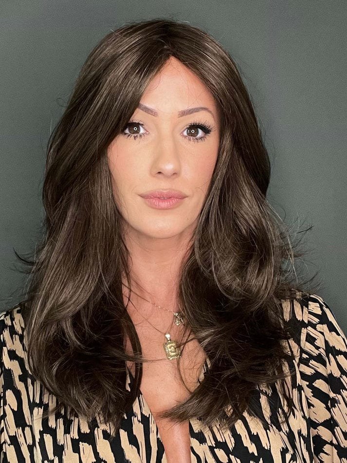 Model wearing Brandi Amore wig long natural brown layered waves with center part for everyday wear